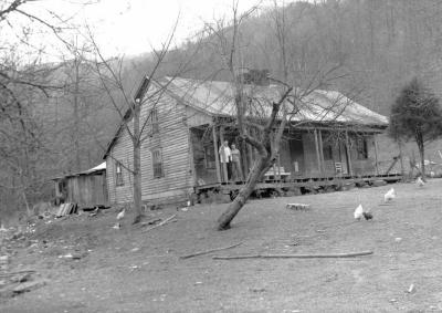 Couple and white dog on the porch of a home