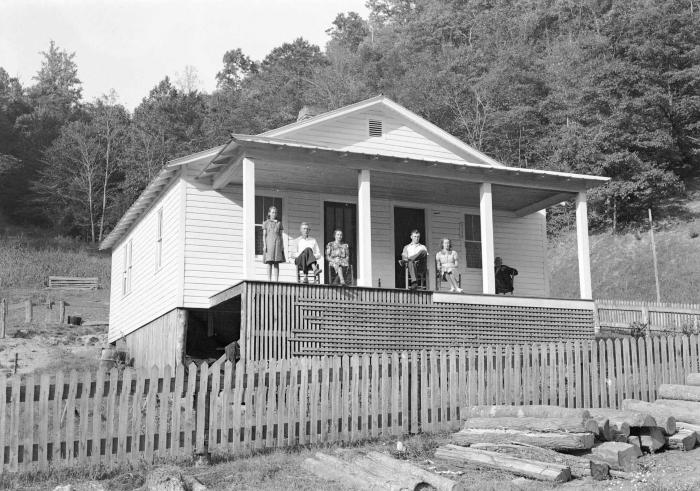 Group portrait on porch, five sitting, one standing