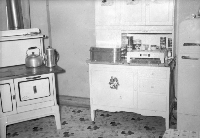 Interior of kitchen with stove, cupboard, and refrigerator