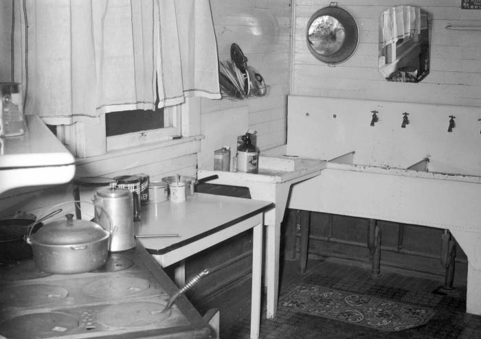 Interior of kitchen with stove, sink, and mirror