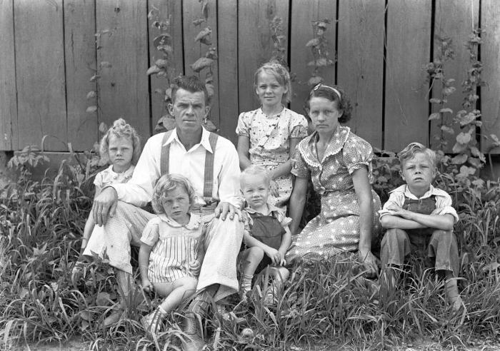 Group portrait of family sitting in grass