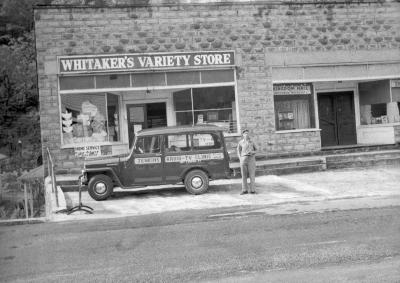 Man posing outside of Whitaker's Variety Store in East Jenkins