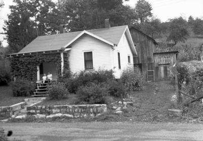 Two children sitting on ivy-covered porch