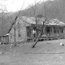 Couple and white dog on the porch of a home