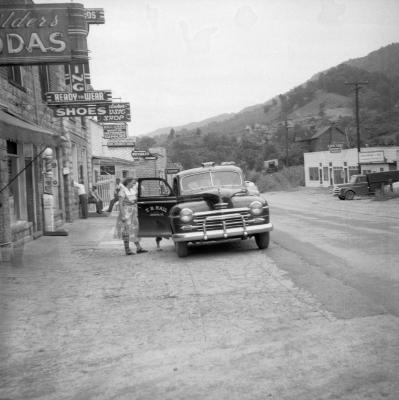 Woman and child entering a car in downtown East Jenkins