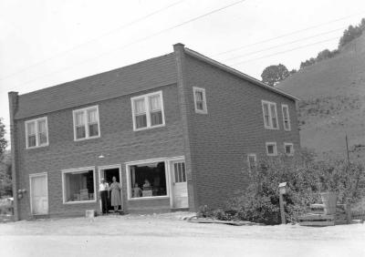 Two adults and two children posing with brick building