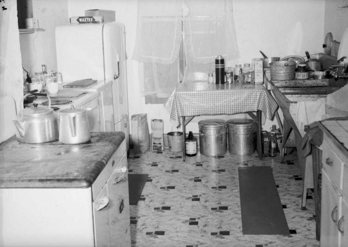 Interior of kitchen with pots, buckets, cooking supplies