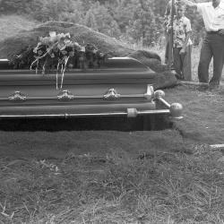 Casket suspended above burial plot, likely the funeral of Denver Wright