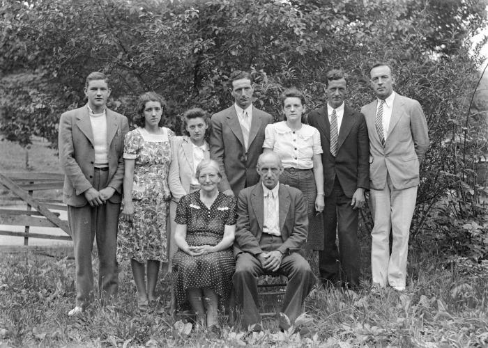Group portrait of nine family members, two seated
