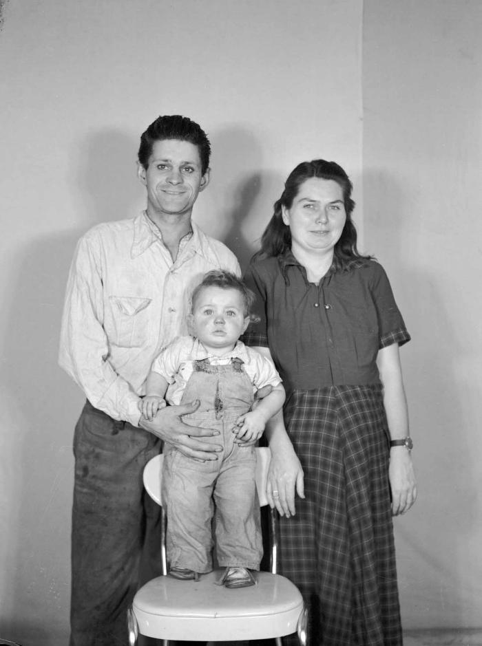 Family portrait with child standing on chair