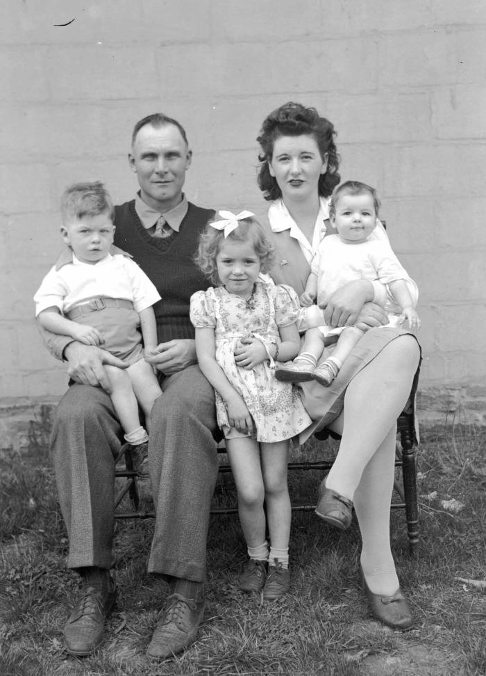 Group portrait of family seated on bench
