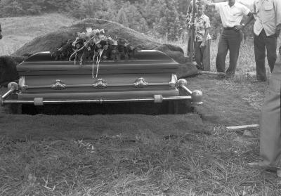 Casket suspended above burial plot, likely the funeral of Denver Wright