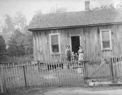 Couple and two children on steps of wooden home