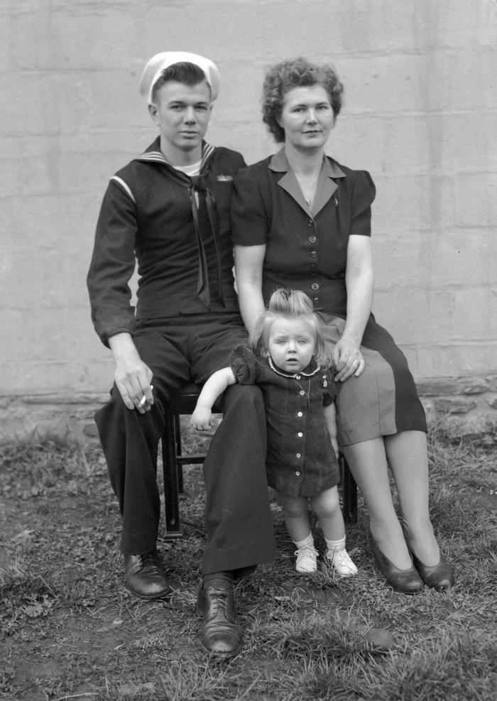 Portrait of couple with child, man in navy uniform
