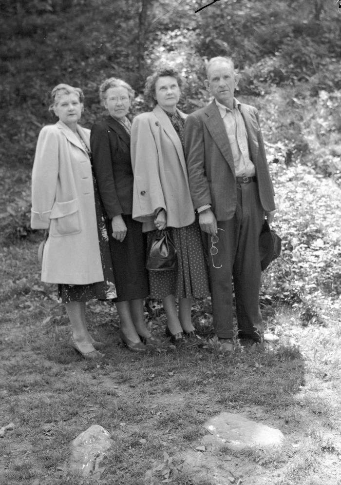 Group portrait, man holding eyeglasses