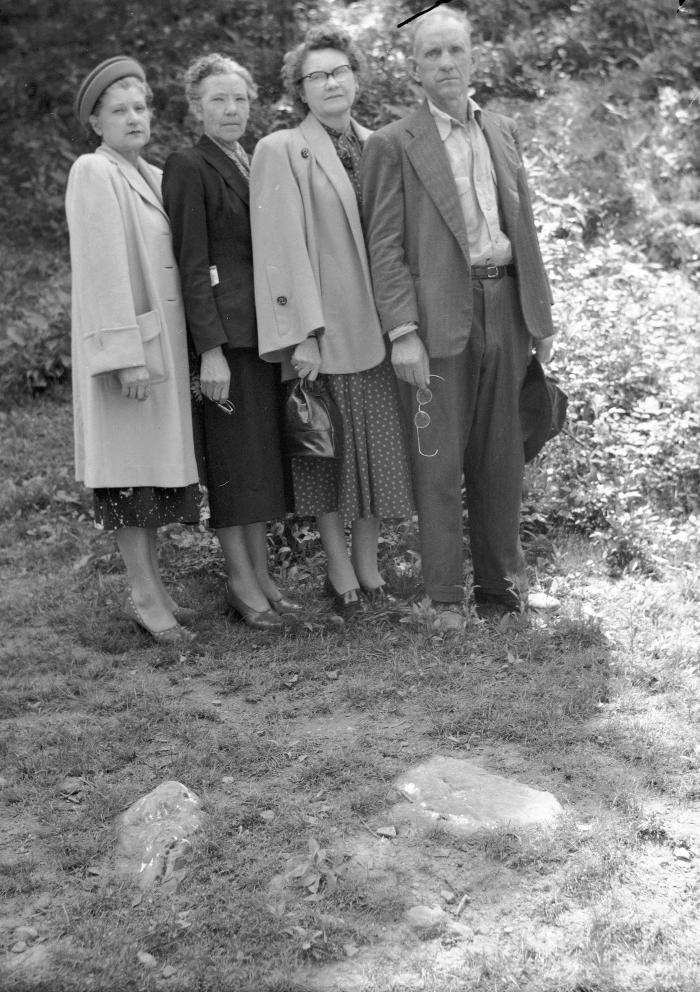 Group portrait, two holding eyeglasses