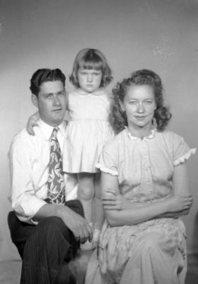 Family portrait of woman, child, and man in floral tie