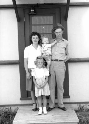 Family portrait on wooden platform in front of black door