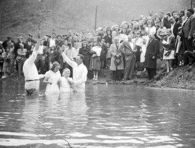 Two children getting baptized in river
