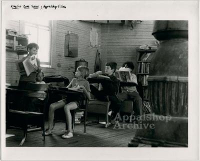 Production still of classroom with children and wood-burning stove -Kingdom Come School